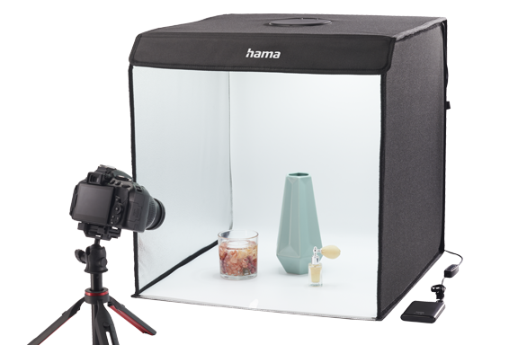 Gegenstände werden mit einer Kamera im Mini-Fototstudio fotografiert.